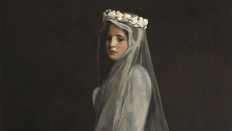 Portrait of a young girl wearing a white communion dress, headdress and veil.