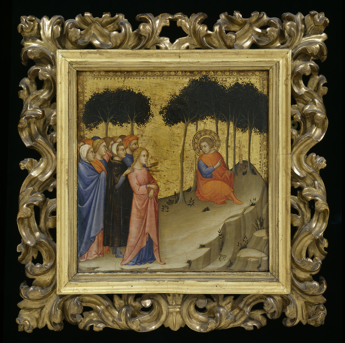 A tempera and gold leaf painting in an elaborate carved fold frame