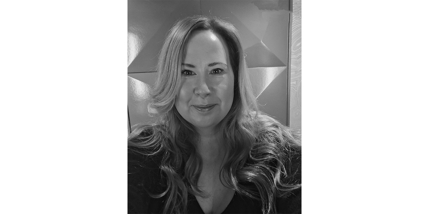 Black and white portrait of a woman with long light coloured hair and a dark top