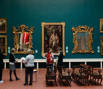 Group of people standing in a historic art gallery