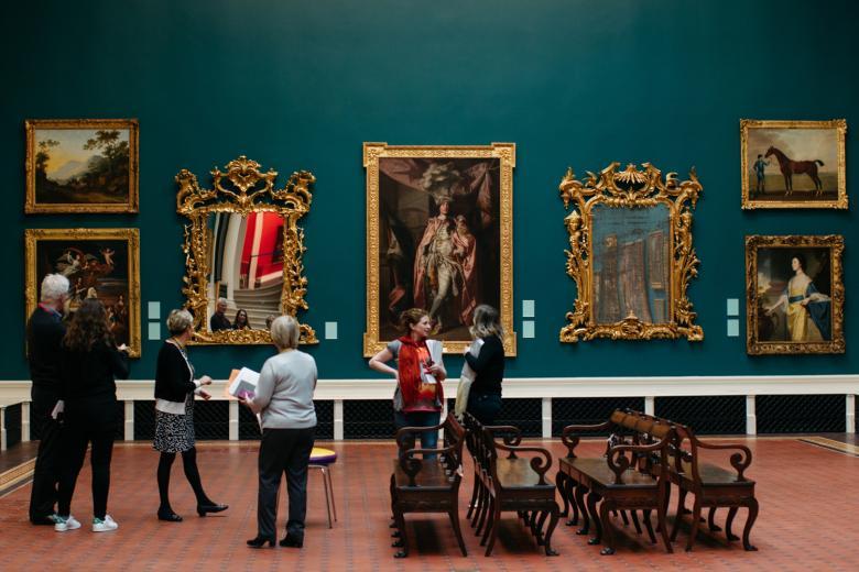Group of people standing in a historic art gallery