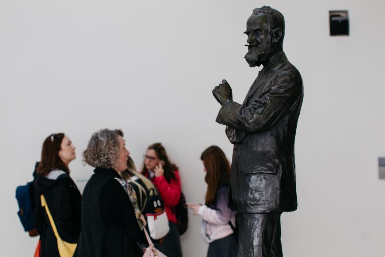 A group of visitors looking at the statue of George Bernard Shaw in the Millennium Wing. © National Gallery of Ireland.