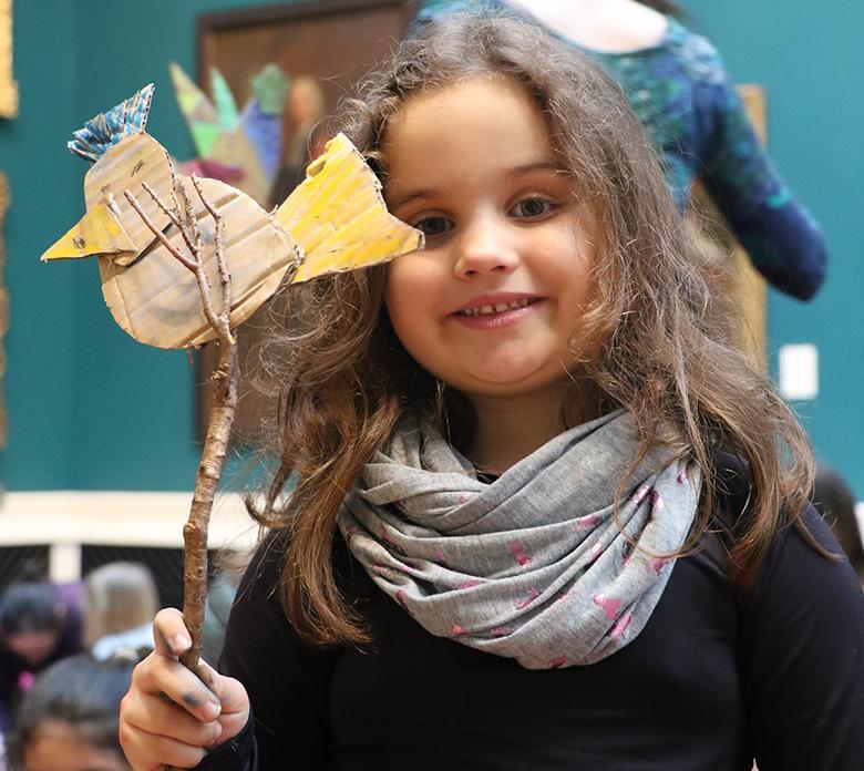 A child holding up her artwork created at a drop-in family workshop in the National Gallery of Ireland.