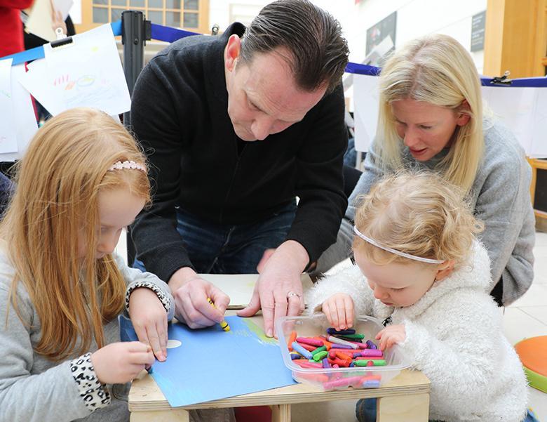 A man, woman and two children working together to create artwork at a drop-in family workshop in the National Gallery of Ireland.