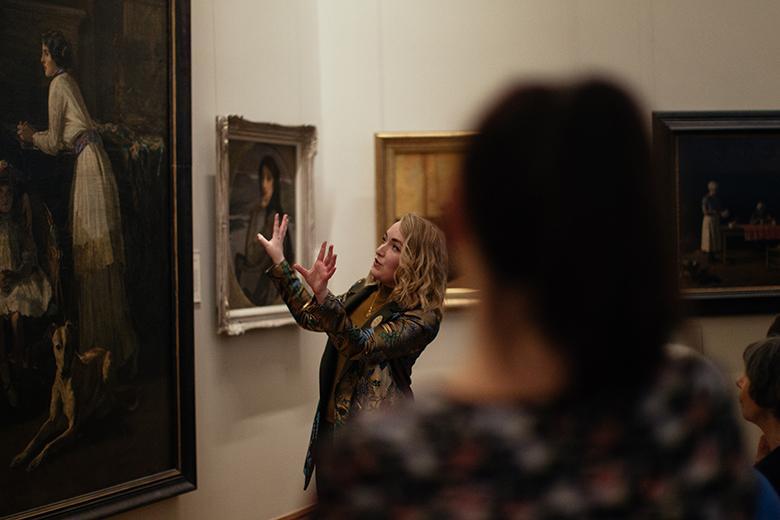 A tour guide speaking speaking about a painting