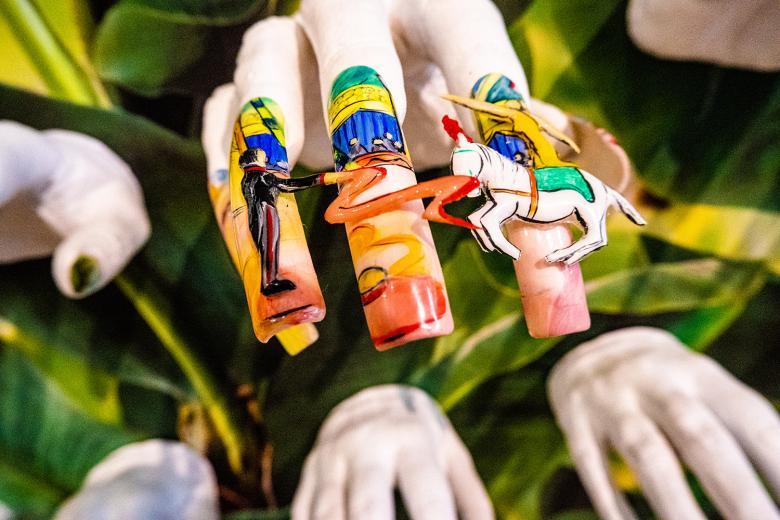 Photo of a plaster cast hand displaying elaborate nail art.