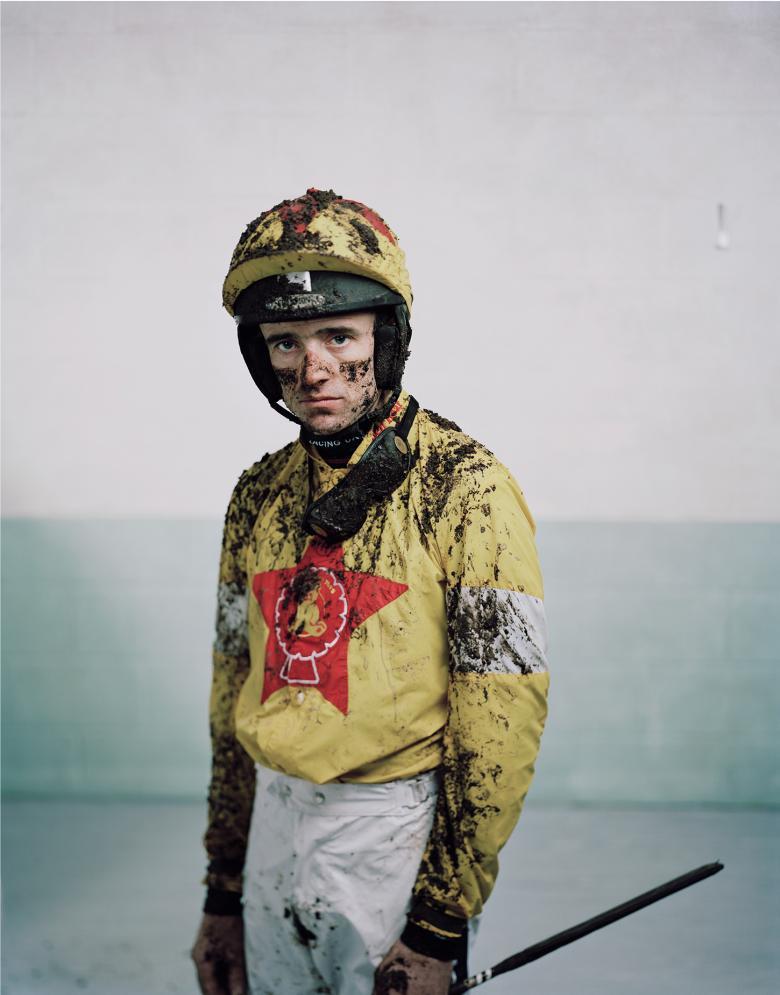 Photo of a jockey covered in mud