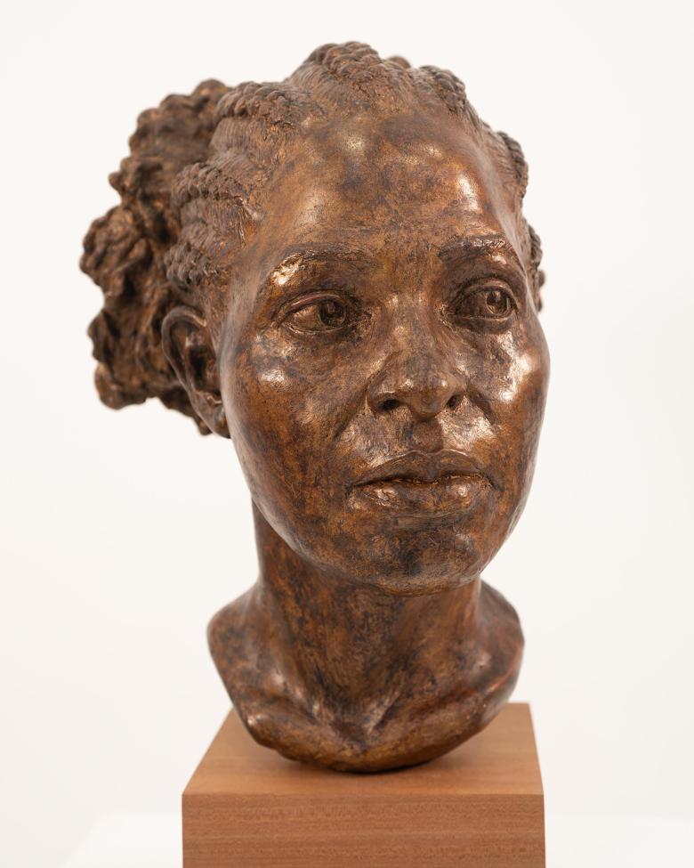 A resin bust on a mahogany base.