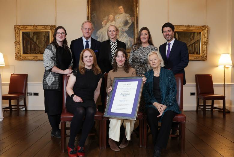 Photograph of a group of eight people in a grand room