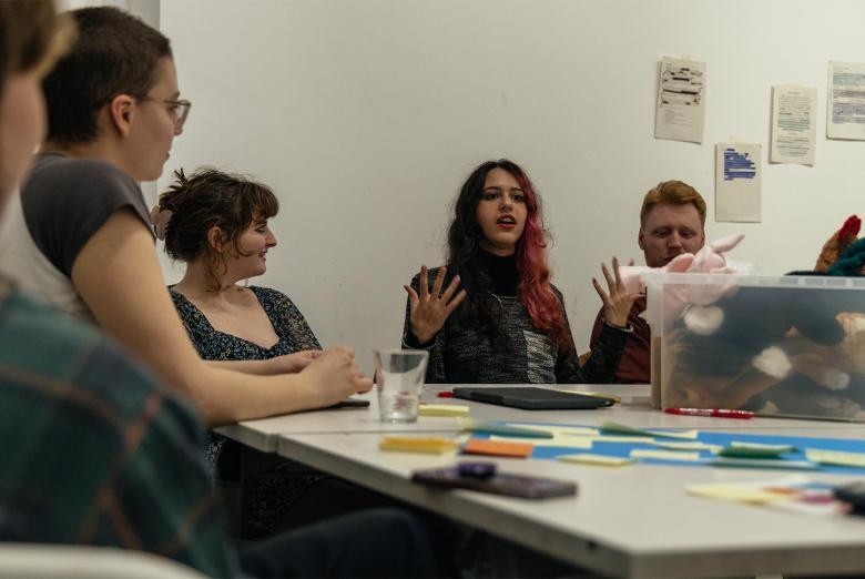 Photograph of young people speaking animatedly around a table