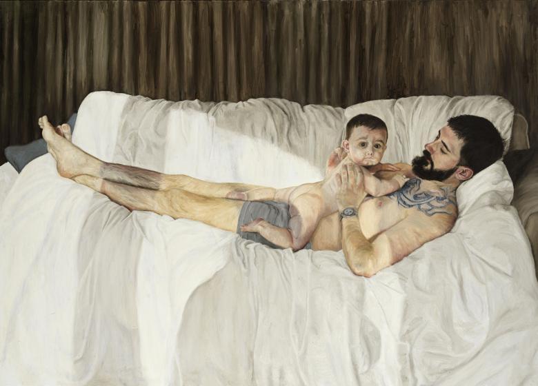A young man lies on a white duvet in his boxers, a baby on his chest. The baby looks at the viewer, the man looks at the baby. There is a shadow of another figure, the artist, on the two.