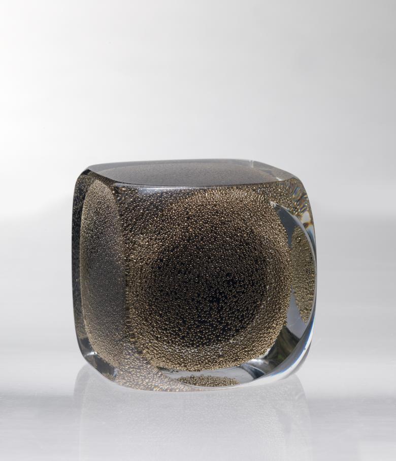 A cubed paperweight made of black glass