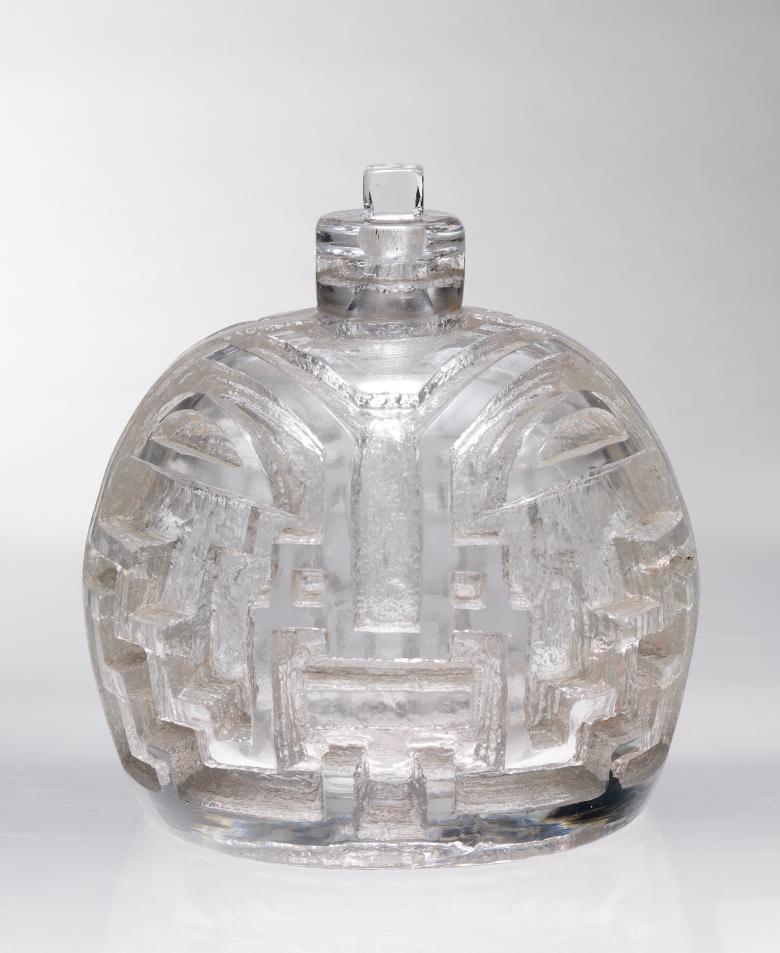 A clear glass flagon with engraved surface.