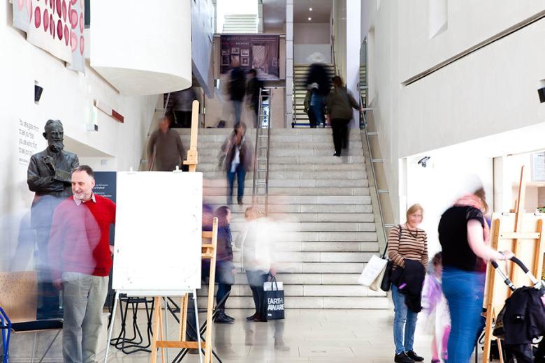 Larges blank canvases rest on on easels in bustling Millennium Wing. 
