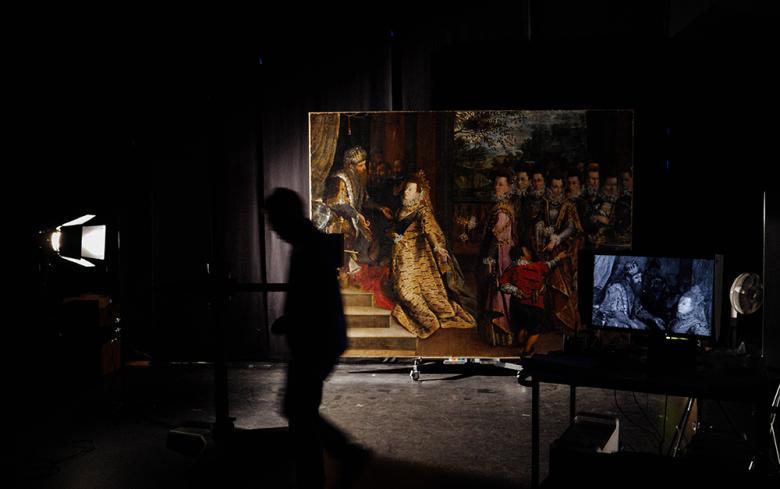 Photo of a large painting in a darkened room with silhouette of figure walking past