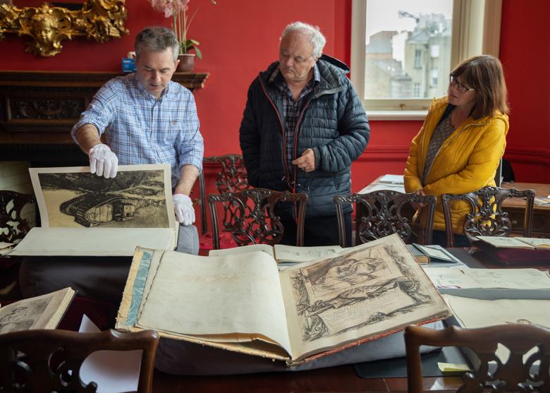 People looking at a display of old, rare illustrated books