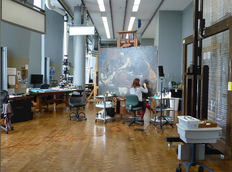A view of the conservation studio in the Getty Museum with maria Canavan working on Guercino's painting called Jacob Blessing the Sons of Joseph.