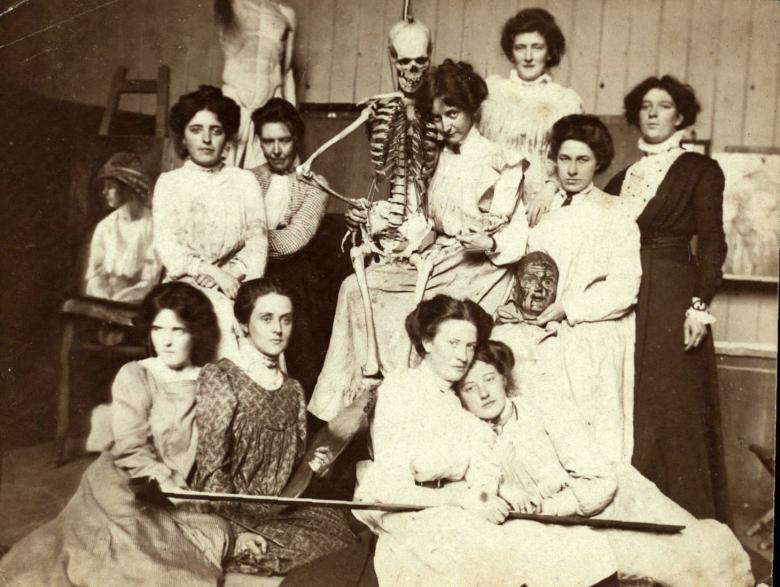 Vintage black and white photo of women posing with a medical skeleton model