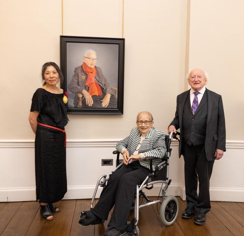 Artist Miseon Lee, former Supreme Court Judge Catherine McGuinness, President Michael D. Higgins pose next to a portrait of Catherine McGuinnessand 
