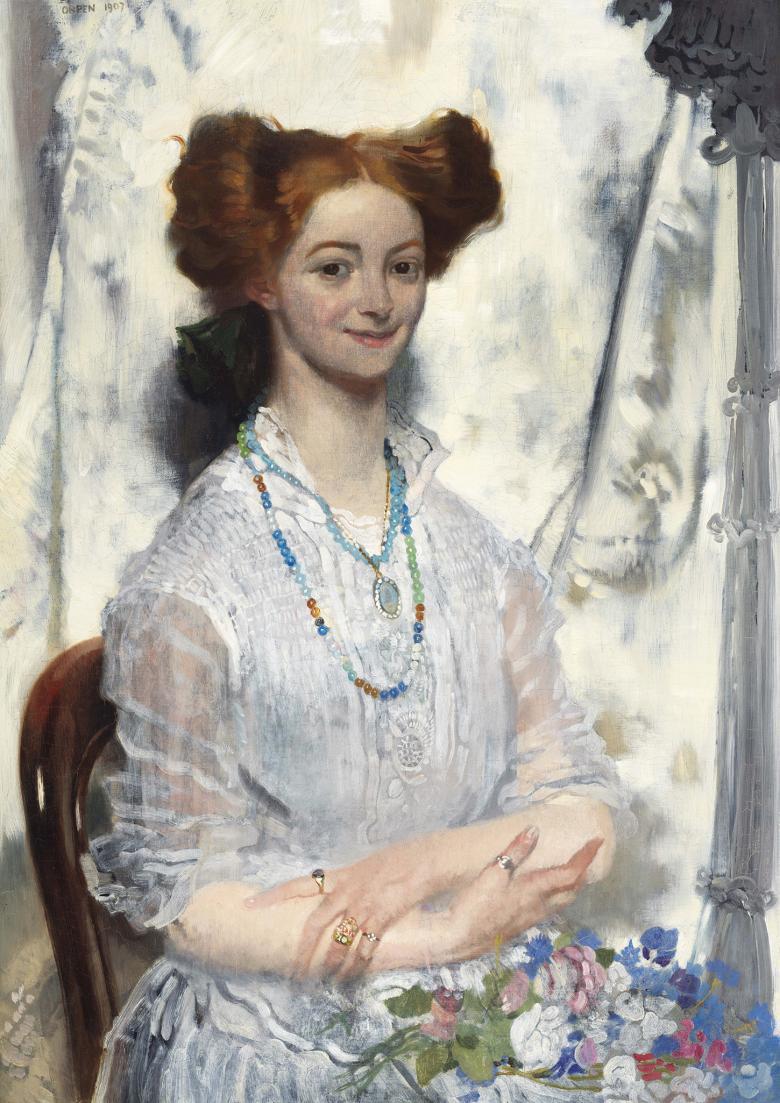 A woman with vibrart red hair in an updo smiles at the viewer. She wears a white dress and has flowers on her lap. Around her neck she has beaded necklaces, and has rings on her fingers. 