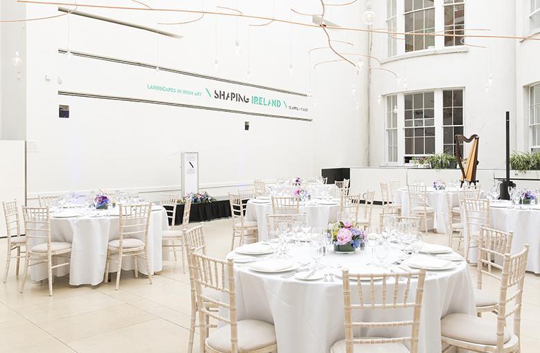 Large white room with round white tables and chairs