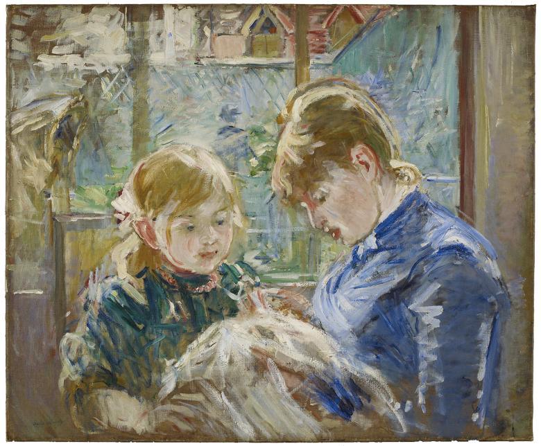 A woman in blue bends over some sewing, with a child looking on. 