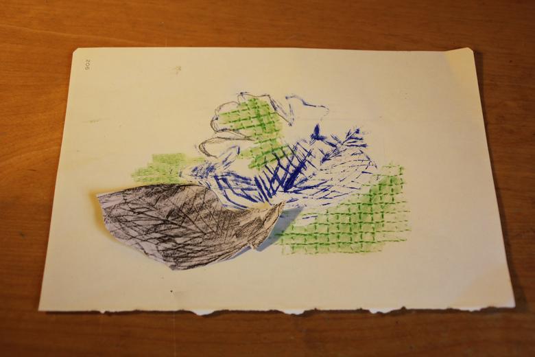 A mixed media print in blue, green and brown on a sheet of white paper.