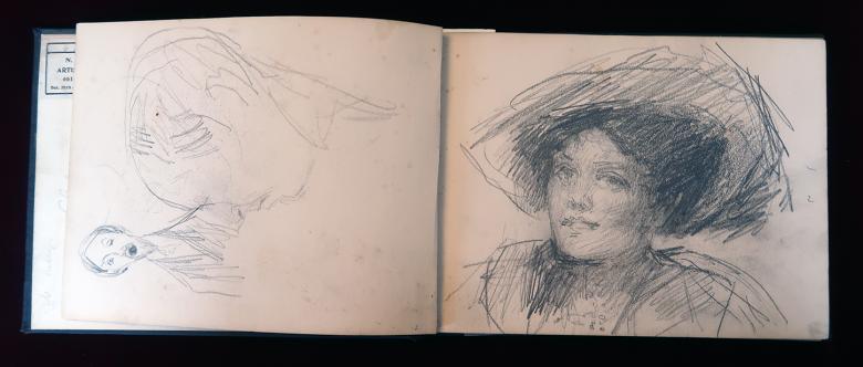 Sketch of a woman in an open sketchbook