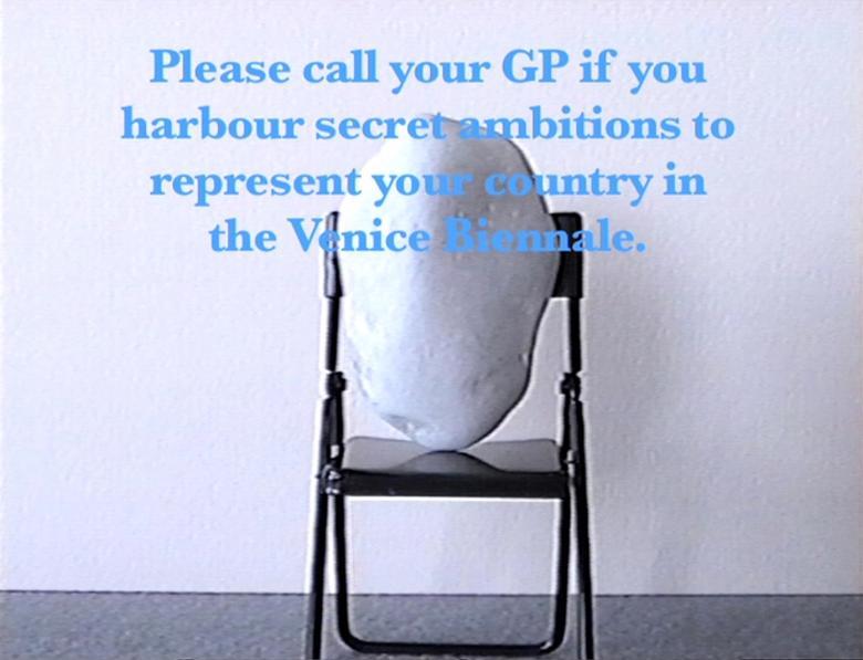 A still from a film showing a stone on a folding chair. Blue text overlaid on the image says "Please call your GP if you harbour secret ambitions to represent your country in the Venice Biennale".