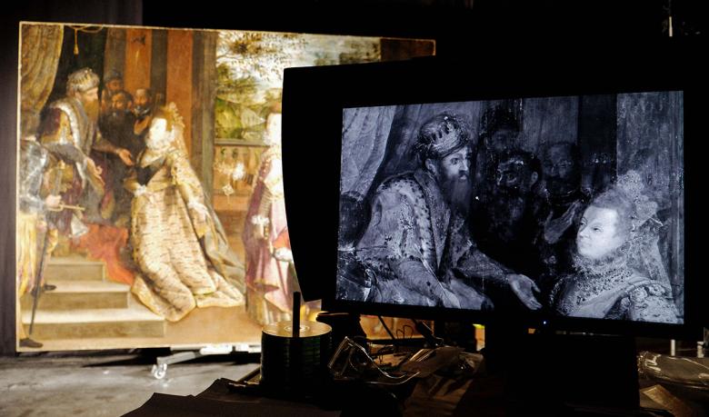 A monitor in a studio showing an infrared image of Lavinia Fontana's painting with the painting partially visible in the background.