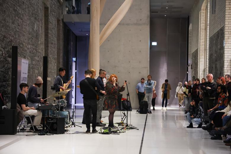 A band performing in the courtyard area with a rapt audience looking on