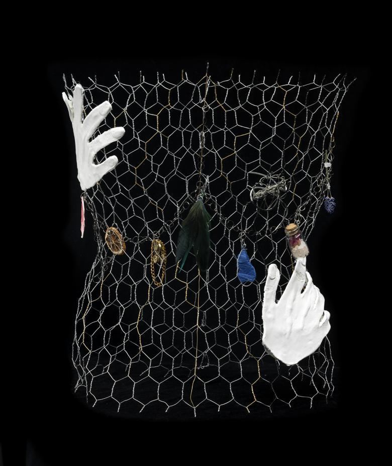 Chicken wire with white clay hands and found objects attached