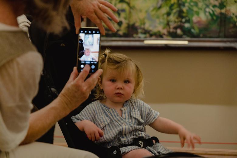 A toddler in a buggy getting her photo taken  in the Gallery