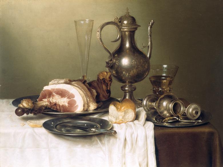 A still life featuring a large joint of ham on a silver platter, a silver jug, a small piece of bread and other silver plates and items on a table.