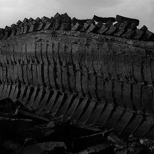 A black and white photograph of a hand-cut bog with the vertical and diagonal cut lines visible.