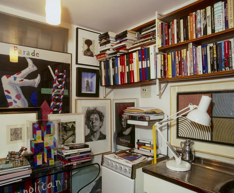 Photo of the corner of Alexander Walker's kitchen with bookshelves and art covering the walls.