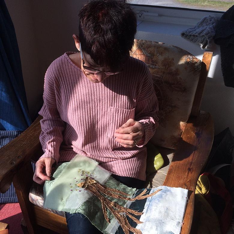 Woman embroidering a tree on fabric