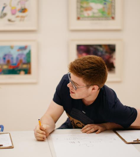 Two students drawing at a table