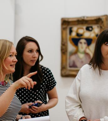 Three women in an art gallery