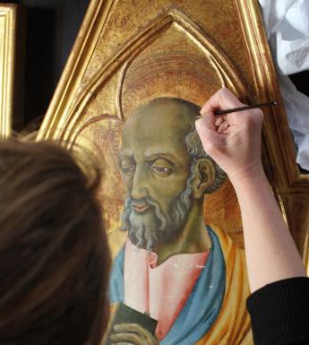 Conservator retouching an altarpiece painting