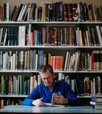 A man reading a book in a library