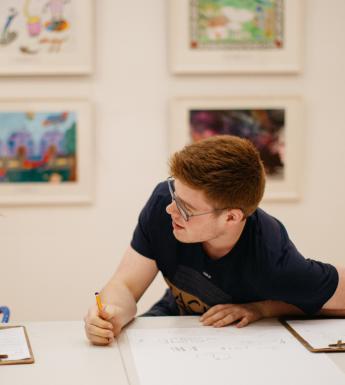 Two students drawing at a table