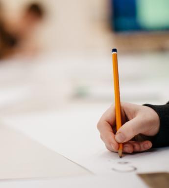 A child drawing a picture with a pencil