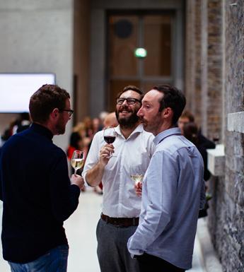 Three men drinking wine at an event
