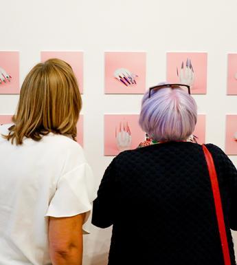 Photo of two women looking at photographs of nail art
