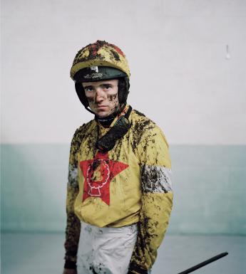 Photo of a jockey covered in mud