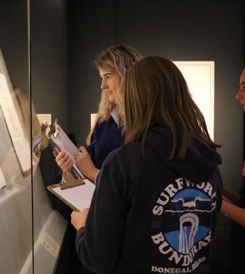 Three teenagers in a print exhibition