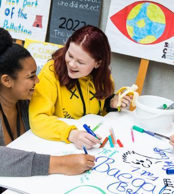 Two teens drawing together at the Creative Schools event in the Gallery