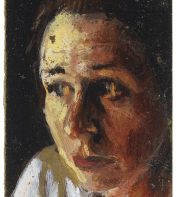 A close up portrait of a woman's head, turned slightly to the side and illuminated by a warm yellow light.