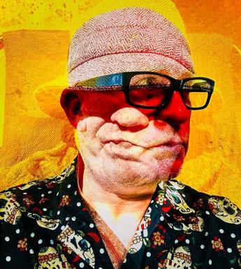 A man wearing a skull print shirt, glasses and a pink hat shakes his head.